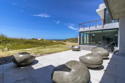 a house with large metal spheres on a patio at The Dunes in Bettyʼs Bay