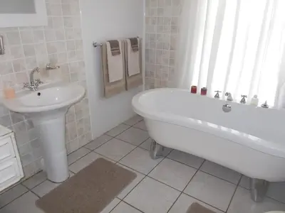 a white bathroom with a tub and a sink at Erf 473 Fisherhaven in Fisherhaven
