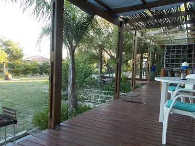 a wooden deck with a table and chairs on it at Erf 473 Fisherhaven in Fisherhaven