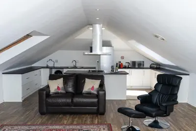 a living room with a couch and two chairs at Woodbridge Lodge in Cape Town