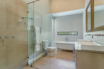 a bathroom with a tub and a toilet and a sink at Swallows Summer Home in Paarl