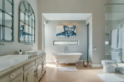 a bathroom with a tub and a sink at Swallows Summer Home in Paarl