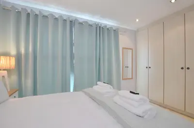 a bedroom with a bed with white towels on it at Church View Lux Apartment in Stellenbosch
