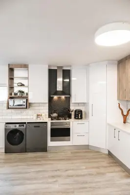a kitchen with white cabinets and a dishwasher at Hermanus Reefs in Hermanus