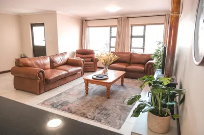 a living room with leather couches and a coffee table at Hermanus Reefs in Hermanus