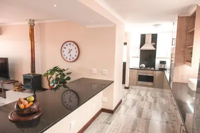 a large kitchen with a clock on the wall at Hermanus Reefs in Hermanus