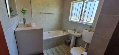 a bathroom with a sink and a toilet and a bath tub at 4859 Lakeside in Bettyʼs Bay