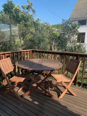 a picnic table and two chairs on a deck at Two Palms Cottage in Hermanus