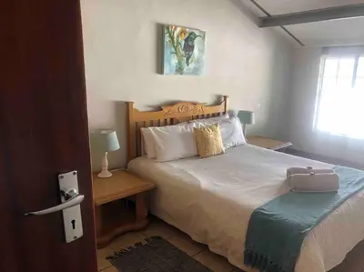 a bedroom with a bed with a suitcase on it at Winecellar Cave, on wine farm & where lions roar! in Stellenbosch