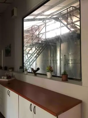 a kitchen with a window in a room with plants at Winecellar Cave, on wine farm & where lions roar! in Stellenbosch