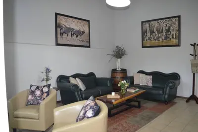a living room with couches and a table at Winecellar Cave, on wine farm & where lions roar! in Stellenbosch