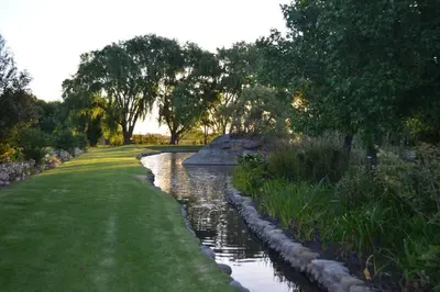 a river with grass and trees in a park at Winecellar Cave, on wine farm & where lions roar! in Stellenbosch