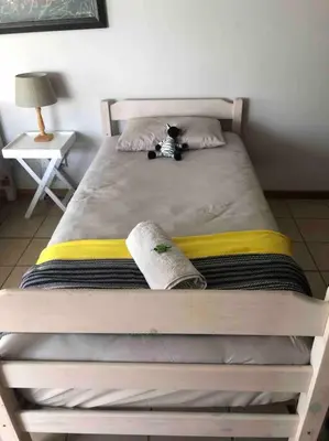 a bed with a stuffed animal sitting on top of it at Winecellar Cave, on wine farm & where lions roar! in Stellenbosch
