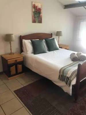 a bedroom with a large bed with two night stands at Winecellar Cave, on wine farm & where lions roar! in Stellenbosch