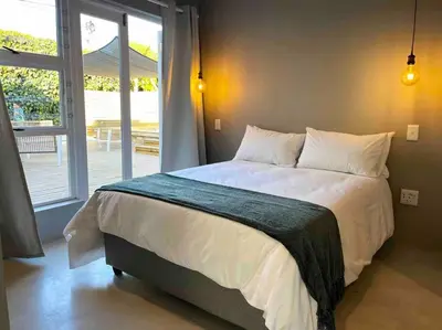 a bedroom with a large bed and a large window at Amazing Brand New Holiday Home with Pool! in Hermanus
