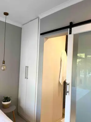 a bathroom with a sliding glass door to a bedroom at Amazing Brand New Holiday Home with Pool! in Hermanus
