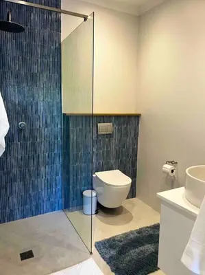 a bathroom with a toilet and a glass shower at Amazing Brand New Holiday Home with Pool! in Hermanus