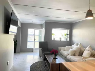 a living room with a white couch and a chair at Amazing Brand New Holiday Home with Pool! in Hermanus