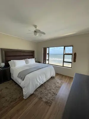 a bedroom with a large bed and a large window at Sea View Serenity on Strand in Cape Town