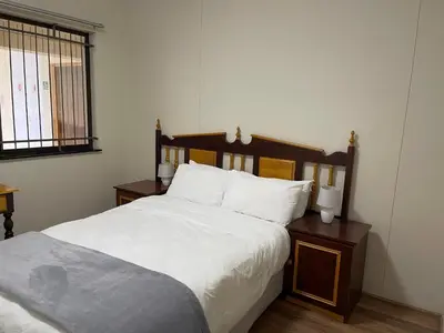 a bedroom with a large bed with white sheets and pillows at Sea View Serenity on Strand in Cape Town