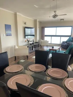 a living room with a table with plates on it at Sea View Serenity on Strand in Cape Town