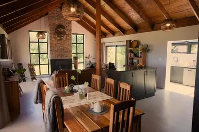 a dining room and kitchen with a table and chairs at Cozy House with Sea and Mountain Views in Bettyʼs Bay