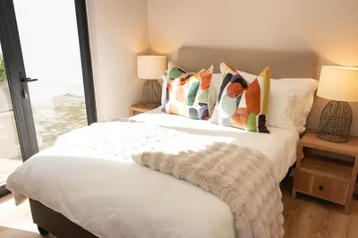 a bedroom with a large bed with pillows at Bikini House - With Pool in Hermanus