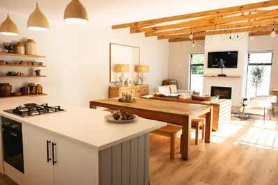 a kitchen and living room with a wooden table at Bikini House - With Pool in Hermanus
