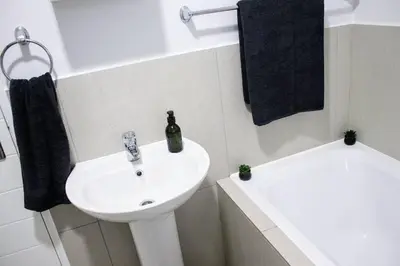 a white bathroom with a sink and a bath tub at 7 on Laibach - Buhrein Estate, Kraaifontein in Cape Town