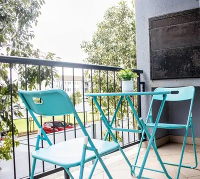 two chairs and a table on a balcony at 7 on Laibach - Buhrein Estate, Kraaifontein in Cape Town