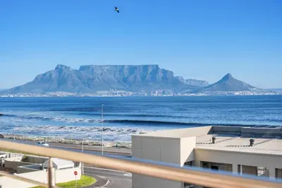 a view of the ocean with a mountain in the background at The Waves 302 in Cape Town
