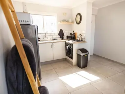 a kitchen with a sink and a stove top oven at Seaside Serenity in Hermanus