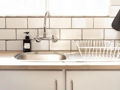 a kitchen sink with a dish drying rack next to it at Seaside Serenity in Hermanus