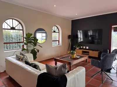 a living room with a couch and a table at B Shocked Manor - Lux Suites in Cape Town