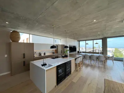 an open kitchen and dining room with views of the ocean at The Hermanus Retreat in Hermanus