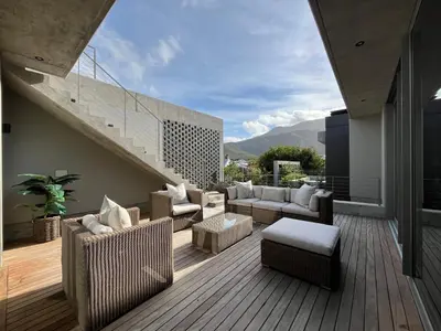 a patio with couches and chairs on a deck at The Hermanus Retreat in Hermanus