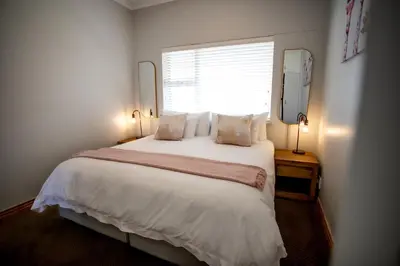 a bedroom with a large white bed with a window at Bayview 307 in Hermanus