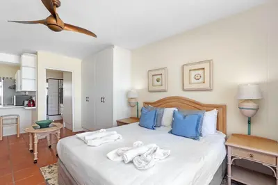 a bedroom with a large white bed with blue pillows at Sea Spray A410 in Cape Town