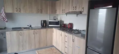 a kitchen with wooden cabinets and a stainless steel refrigerator at 35 Amanda - Durbanville in Cape Town