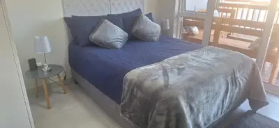 a bed with blue sheets and pillows in a bedroom at 35 Amanda - Durbanville in Cape Town