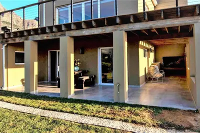 an outdoor patio with a wooden pergola at Heuwels in Blauwvlei