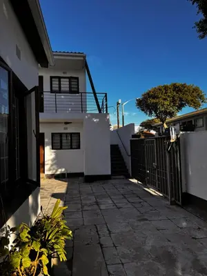 a white house with a gate and a patio at Mila Lodge 2 in Goodwood
