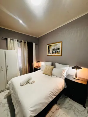 a bedroom with a large bed with white sheets and pillows at Mila Lodge 2 in Goodwood
