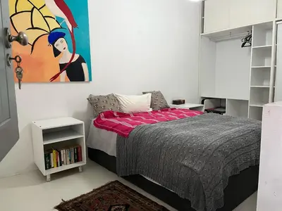 a bedroom with a bed and a painting on the wall at Sublime modern beachfront villa in paradise in Hawston