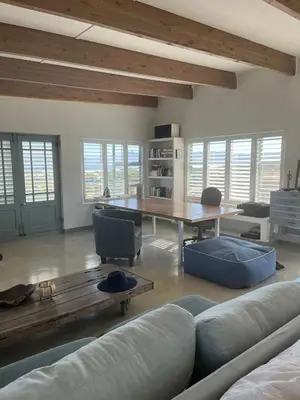 a living room with a table and a couch at Sublime modern beachfront villa in paradise in Hawston