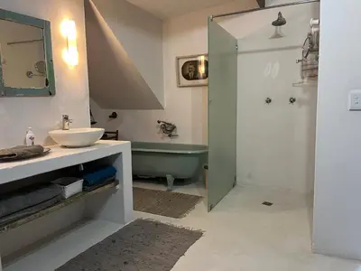 a bathroom with a sink and a bath tub and a sink at Sublime modern beachfront villa in paradise in Hawston