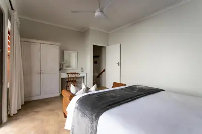 a bedroom with a large white bed in a room at Plaisir du Cap in Hermanus