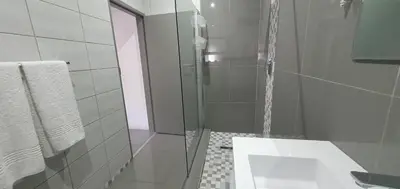 a bathroom with a glass shower and a sink at 1 On Sonnet Unit Mia in Cape Town