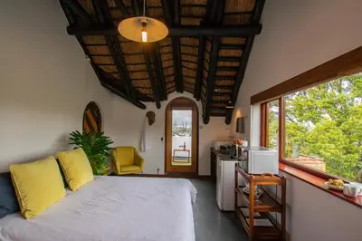a bedroom with a bed and a kitchen with a window at Mountain View and Vineyard View in Suider-Paarl