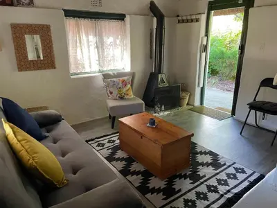 a living room with a couch and a coffee table at Mouse House Greyton - tiny home living in Greyton